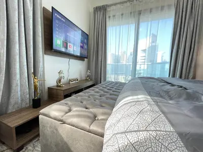 a bedroom with a large bed and a flat screen tv at Luxury Room with Marina view close to JBR Beach and Metro with Shared Kitchen in Dubai