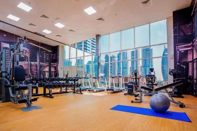 a gym with exercise equipment and a view of the city at Regency Luxury Suites in Dubai