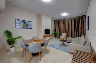 a living room with a table and chairs and a couch at Regency Luxury Suites in Dubai