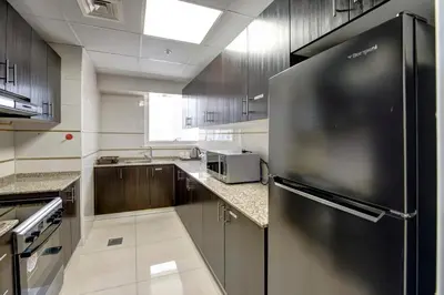 a kitchen with a stainless steel refrigerator in it at Regency Luxury Suites in Dubai