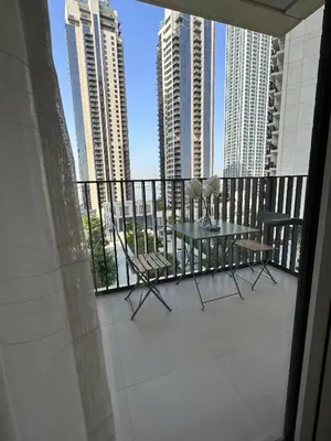 a balcony with a table and chairs and tall buildings at 3BR Haven with Burj Views by MagnoliasVHR in Dubai