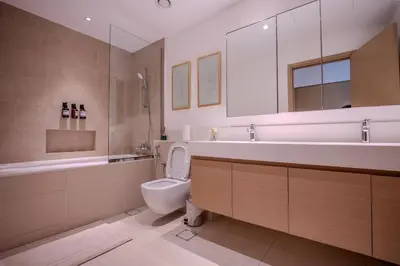 a bathroom with a toilet and a sink and a mirror at 3BR Haven with Burj Views by MagnoliasVHR in Dubai