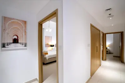 a hallway of a hotel room with a bed and a mirror at 3BR Haven with Burj Views by MagnoliasVHR in Dubai