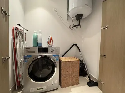 a washing machine in a laundry room with a lamp at 3BR Haven with Burj Views by MagnoliasVHR in Dubai