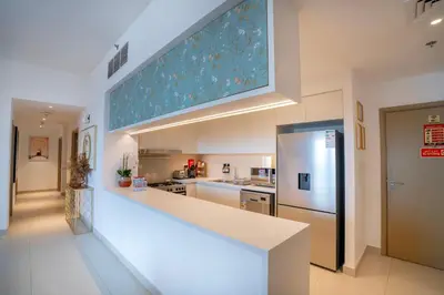 a kitchen with a large counter and a refrigerator at 3BR Haven with Burj Views by MagnoliasVHR in Dubai
