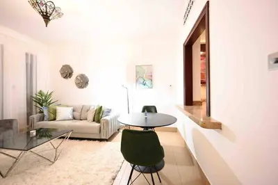 a living room with a table and a couch at Brand new furniture . Close to Dubai Mall. in Dubai