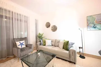 a living room with a couch and a glass table at Brand new furniture . Close to Dubai Mall. in Dubai