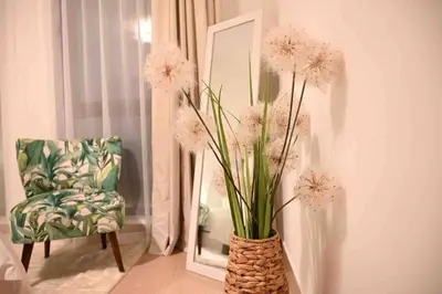 a vase filled with white flowers sitting next to a mirror at Brand new furniture . Close to Dubai Mall. in Dubai
