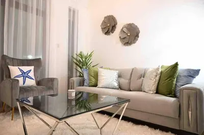 a living room with a couch and a glass table at Brand new furniture . Close to Dubai Mall. in Dubai