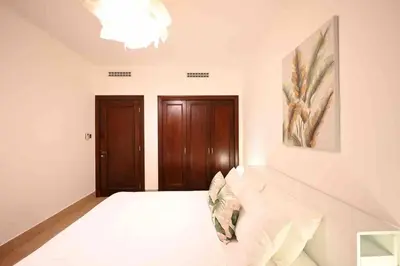 a white room with a bed and a painting on the wall at Brand new furniture . Close to Dubai Mall. in Dubai