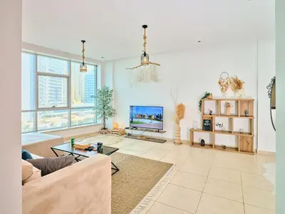 a living room with a couch and a tv at Wonderful two bed room with full marina view in Dubai