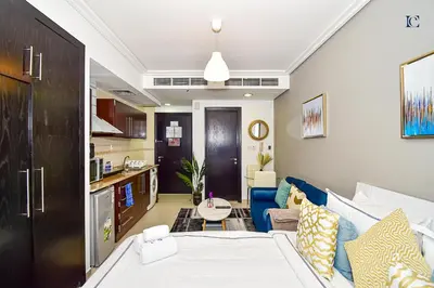 a living room with a bed and a couch at Luxury Escapes - Cozy Studio with Balcony near Metro - Goldcrest 2 JLT in Dubai