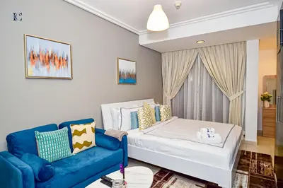a living room with a couch and a bed at Luxury Escapes - Cozy Studio with Balcony near Metro - Goldcrest 2 JLT in Dubai