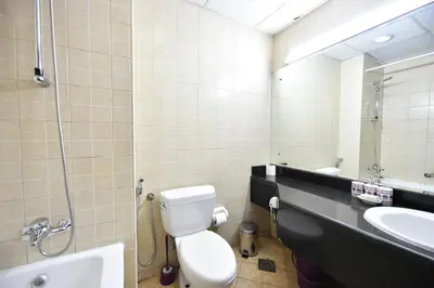 a bathroom with a toilet and a sink and a mirror at Luxury Escapes - Budget-Friendly Studio Near Metro - MED67 DG in Dubai