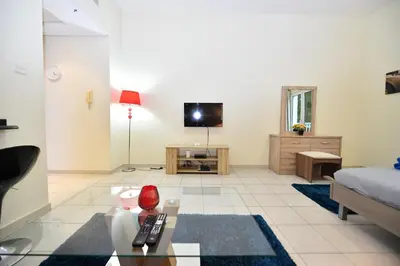 a living room with a couch and a tv at Luxury Escapes - Budget-Friendly Studio Near Metro - MED67 DG in Dubai