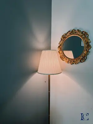 a lamp and a mirror next to a wall at Brand New Studio Apt - Near JLT Metro in Dubai