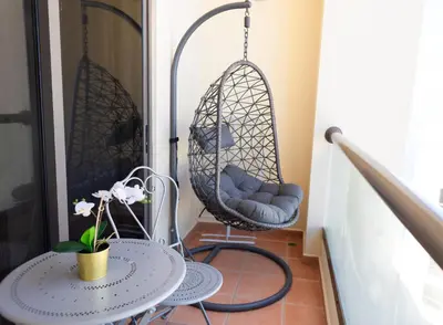 a porch with two swing chairs and a table at Apartments on JBR by HAPPY SEASON in Dubai