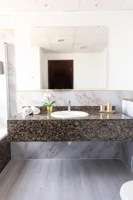a bathroom with a sink and a large mirror at Apartments on JBR by HAPPY SEASON in Dubai