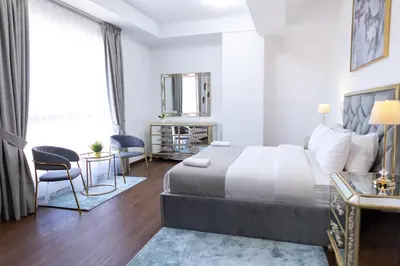 a bedroom with a bed and a table and chairs at Apartments on JBR by HAPPY SEASON in Dubai