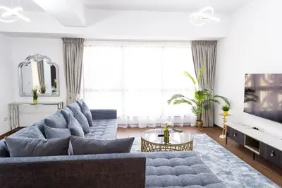 a living room with a blue couch and a table at Apartments on JBR by HAPPY SEASON in Dubai
