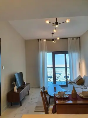 a living room with a view of the ocean at Cozy 1-bedroom apartment in Dubai South with Pool in Dubai