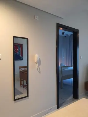 a room with a mirror and a phone on a wall at Cozy 1-bedroom apartment in Dubai South with Pool in Dubai