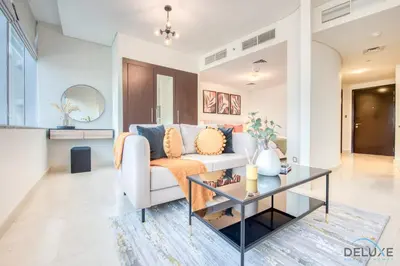 a living room with a couch and a table at Charming Studio at Sky Gardens DIFC by Deluxe Holiday Homes in Dubai