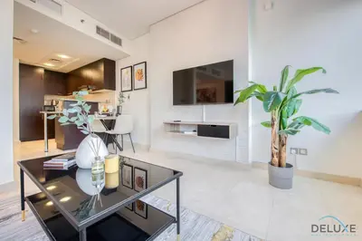 a living room with a glass table and a tv at Charming Studio at Sky Gardens DIFC by Deluxe Holiday Homes in Dubai