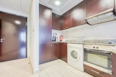 a kitchen with a washer and a washing machine at Charming Studio at Sky Gardens DIFC by Deluxe Holiday Homes in Dubai