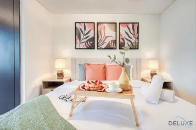 a bedroom with a bed with a tray of food on it at Charming Studio at Sky Gardens DIFC by Deluxe Holiday Homes in Dubai