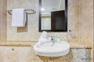 a bathroom with a white sink and a mirror at Charming Studio at Sky Gardens DIFC by Deluxe Holiday Homes in Dubai