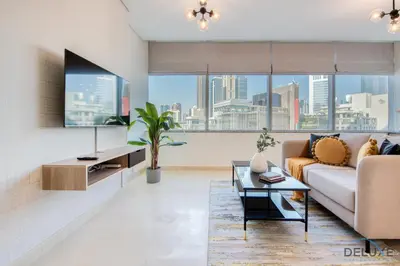 a living room with a couch and a table at Charming Studio at Sky Gardens DIFC by Deluxe Holiday Homes in Dubai