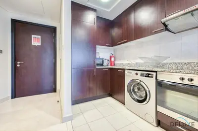 a kitchen with a washer and dryer in it at Special Rate Cozy Studio with Balcony Near Attractions by Deluxe Holiday Homes in Dubai