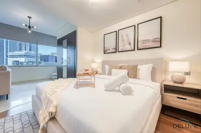 a bedroom with a large white bed and a large window at Special Rate Cozy Studio with Balcony Near Attractions by Deluxe Holiday Homes in Dubai