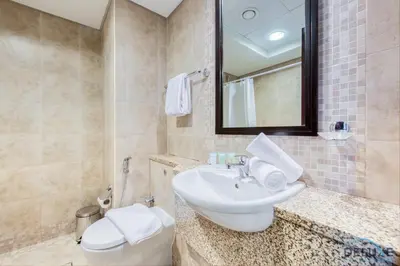 a bathroom with a sink and a toilet and a mirror at Special Rate Cozy Studio with Balcony Near Attractions by Deluxe Holiday Homes in Dubai