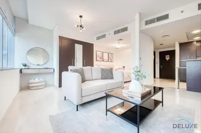 a living room with a white couch and a table at Calm Studio at Sky Gardens DIFC by Deluxe Holiday Homes in Dubai