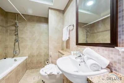 a bathroom with a sink and a tub and a toilet at Calm Studio at Sky Gardens DIFC by Deluxe Holiday Homes in Dubai