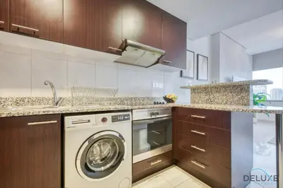 a kitchen with a washing machine and a sink at Calm Studio at Sky Gardens DIFC by Deluxe Holiday Homes in Dubai
