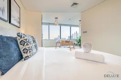 a bedroom with a white bed with blue pillows at Oceanic Studio at Sky Gardens DIFC by Deluxe Holiday Homes in Dubai