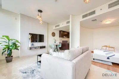 a living room with a white couch and a bed at Oceanic Studio at Sky Gardens DIFC by Deluxe Holiday Homes in Dubai