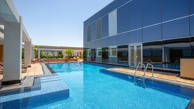 a swimming pool in front of a building at Oceanic Studio at Sky Gardens DIFC by Deluxe Holiday Homes in Dubai