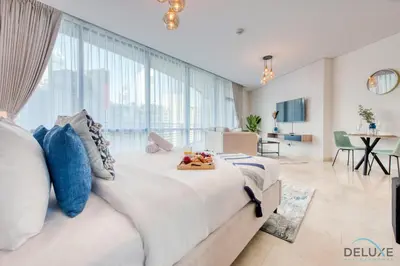 a bedroom with a large bed with a tray of fruit on it at Tranquil Studio at Sky Gardens DIFC by Deluxe Holiday Homes in Dubai