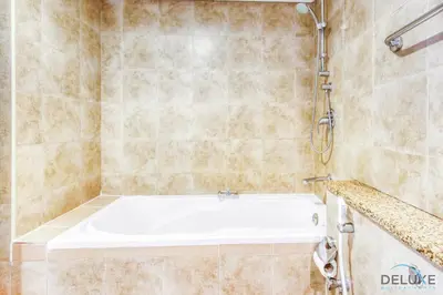 a bathroom with a bath tub and a shower at Tranquil Studio at Sky Gardens DIFC by Deluxe Holiday Homes in Dubai