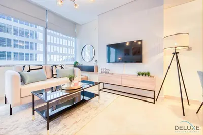 a living room with a couch and a tv at Radiant Studio at Sky Gardens DIFC by Deluxe Holiday Homes in Dubai