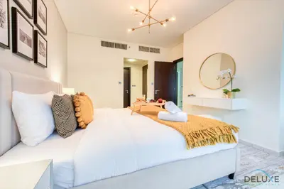 a white bed in a room with a mirror at Gorgeous 1BR at Sky Gardens, DIFC by Deluxe Holiday Homes in Dubai