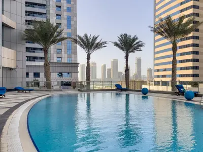 a swimming pool with palm trees and buildings at Marco Polo - Your luxurious high-floor escape in Dubai Marina in Dubai