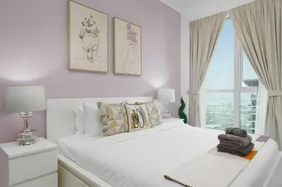 a white bedroom with a large white bed and a window at Marco Polo - Your luxurious high-floor escape in Dubai Marina in Dubai