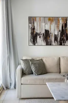 a living room with a couch and a painting on the wall at Frank Porter - Al Thayyal 2, The Greens in Dubai