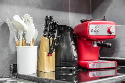 a red mixer sitting on a kitchen counter with utensils at Great Gatsby's Home in Dubai