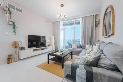 a living room with a couch and a tv at Great Gatsby's Home in Dubai